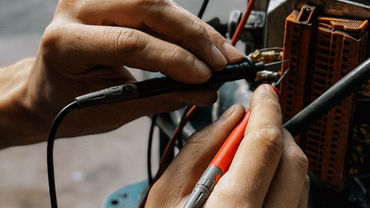 Technician performing electrical verification on a motor during factory quality testing
